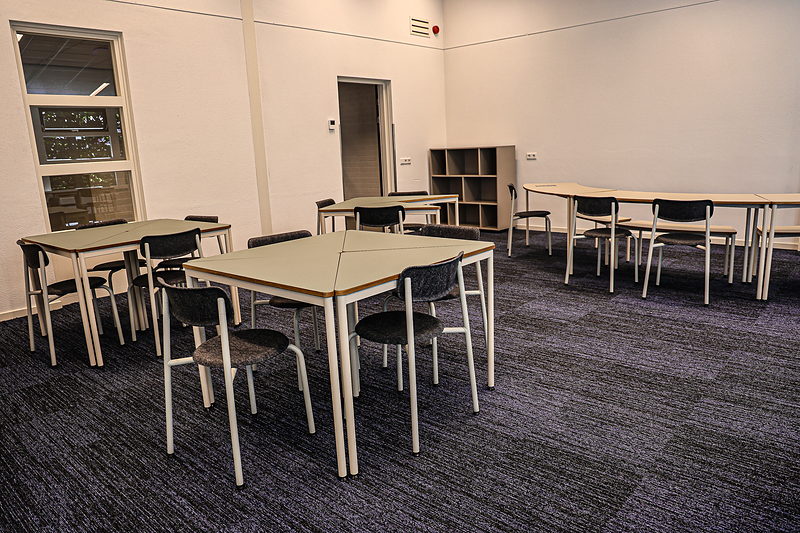 Lokaal van SAM College met losse tafels en stoelen