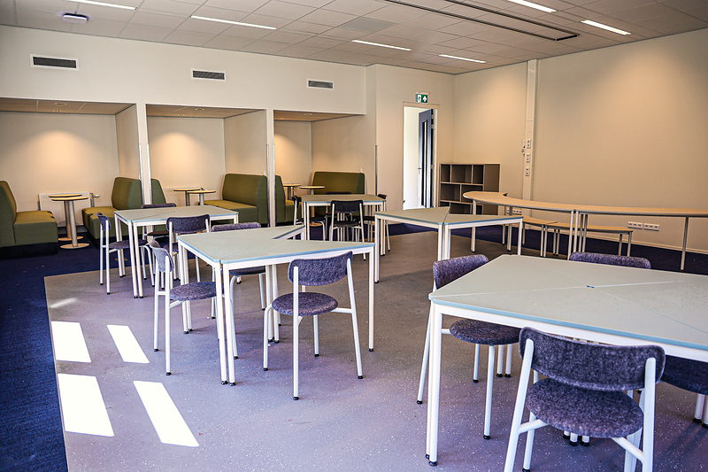 Groene overlegnissen en tafels in een lokaal van SAM College